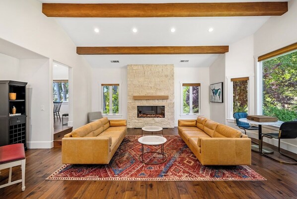 Large formal living room with brand new stone fireplace, piano, game nook and more.