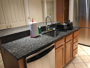 Kitchen with stainless steel appliances, granite counter tops, and tile floors.