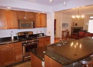 Kitchen with stainless steel appliances, granite counter tops, and tile floors.