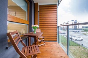 A private balcony with outdoor furniture, perfect for relaxing with a view of the surrounding area. The balcony is spacious and has a modern railing.