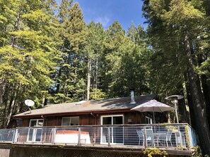 The main house is nestled in redwood trees, has a wrap around deck and hot tub.