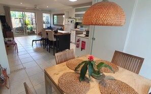 dining table looking back to kitchen and lounge and entrance sliding door 