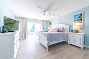 Serene master bedroom with a big screen TV and direct patio access