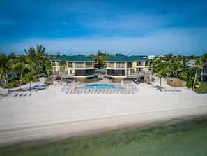 View of the pool and Atlantic Ocean beach with comfortable lounge chairs