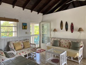 Front room TV, couch, loveseat, and two comfy chairs. Feel of an island cottage.