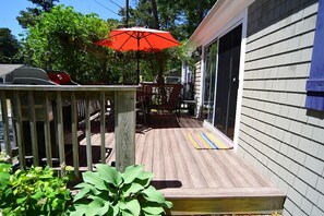 Sunny front deck with dining table and gas grill