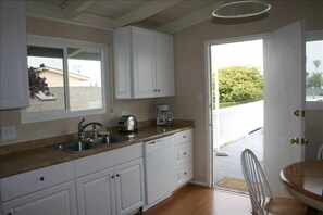 Kitchen window looks onto the balcony and the door opens to the large deck