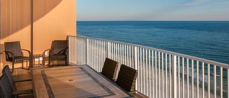 Large balcony with comfortable chairs, dining table, view to east