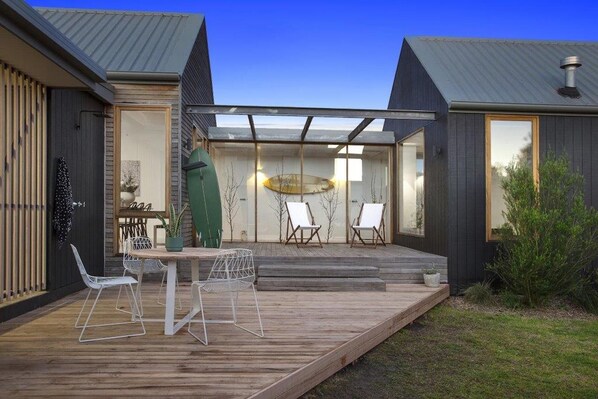 Outdoor decked area with hot/cold shower, ici et la deck chairs and surfboards