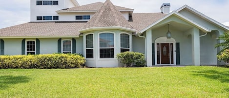 Front of home with large landscaped lot