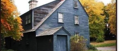 Southeast corner showing salt box addition and field stone and brick chimney.
