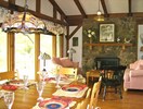 Greatroom dining & sitting, window wall & fieldstone fireplace