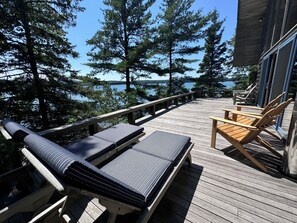large deck with 2 lounge and 4 comfortable Adirondack chairs