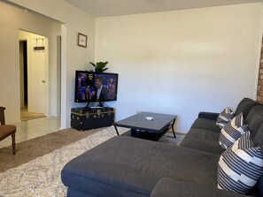 Long comfortable new couch in Living Room with HDTV, desk, games and library.