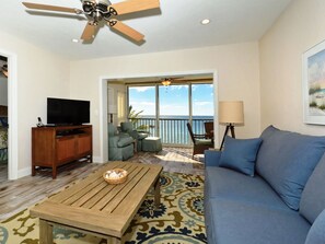 Spacious living room with view out to Lanai, the beach and azure waters of the Gulf of Mexico...large HDTV, stereo, and more...