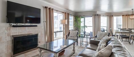 Living room with comfortable seating, TV with Cable, gas fireplace and plenty of natural light