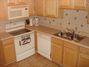 Fully furnished kitchen with dishwasher, microwave