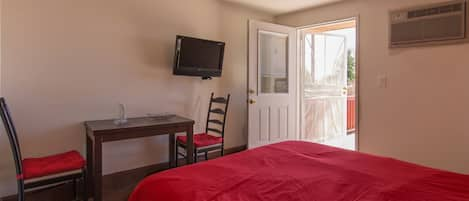 Bedroom with desk and TV. The TV has both cable TV and Apple TV channels.