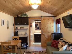 Cutest cabin living with a barn door that slides open & close to the bathroom