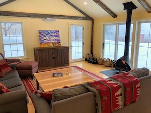 The family room has two large couches, a TV and a free-standing fireplace.