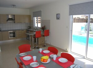 Open plan kitchen / dining area overlooks the pool.