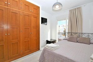 First bedroom with king-size bed, air conditioning, spacious wardrobe and sea views from the balcony