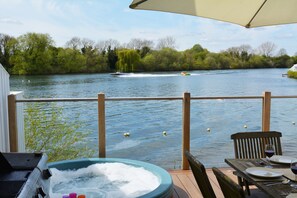 Private secure deck onto Spring Lake with hot tub, table and chairs and BBQ