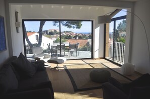 Living room, adjoining kitchen and large front balcony overlooking the sea 