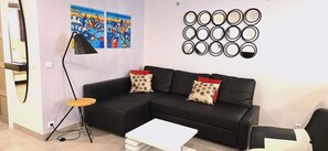 Coin salon avec télévision écran plat et radio/enceinte connectée.