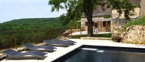 Heated swimming pool, terrace and house in the back