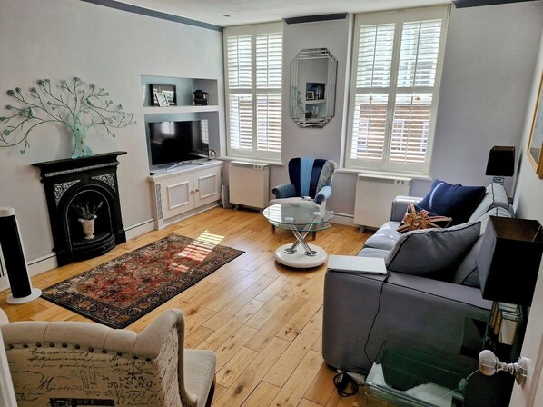 Sitting room is light and airy, with 2 large sash windows overlooking courtyard.