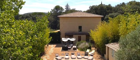 Vue d'ensemble de la villa: la piscine, une partie du jardin, la pergola.