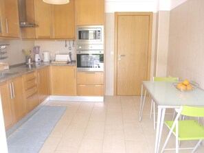 Modern fitted kitchen with electric oven, hob, built in microwave.
