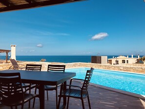 Al fresco dining on the bamboo covered verandah, next to the pool with sea view