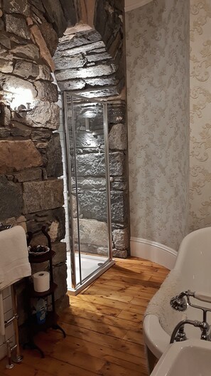 Glass shower cubicle in granite stone archway.