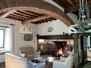 Living with fire place, table, cupboard, board games, lectuur and turist info