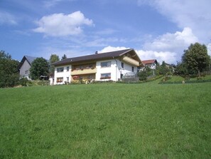 Sommerblick von der Wiese aus auf die Anlage