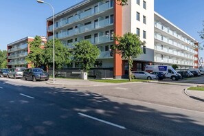A view of the apartment building’s exterior, showcasing its modern architecture in a well-developed neighborhood.