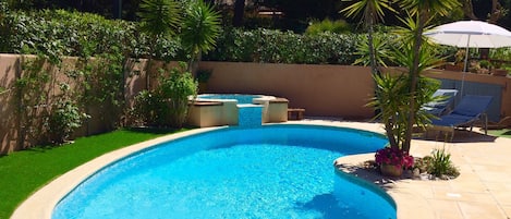 Piscine avec jacuzzi, 6 chaises longues et parasols.