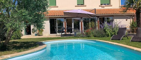 Maison principale - vue du jardin avec piscine. 