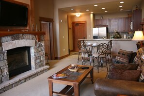 Open concept living space with kitchen,dining & living area with stone fireplace