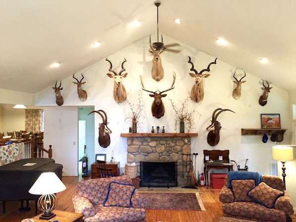 Local stone fireplace surrounded by collection of African taxidermy. 