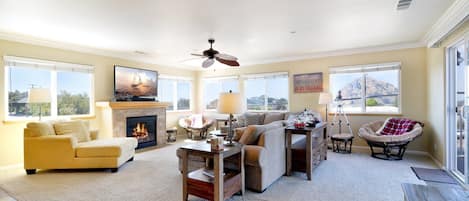 The living room has a fireplace and large flat screen tv. Opens to balcony.