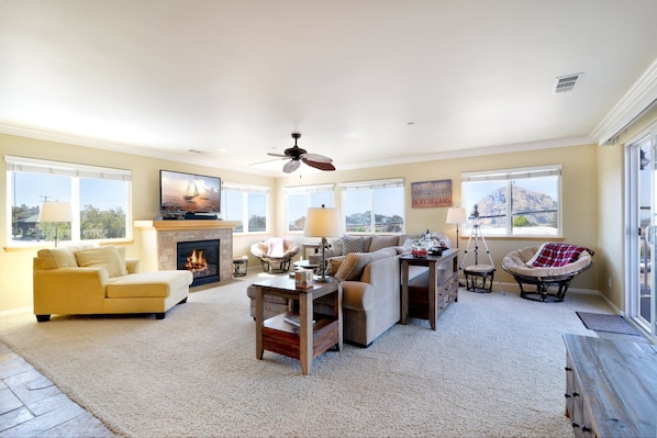 The living room has a fireplace and large flat screen tv. Opens to balcony.