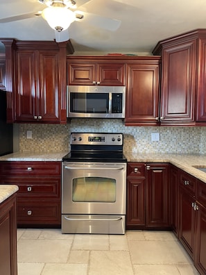 Designer kitchen w/wood cabinets, granite, glass backslash, under-cabinet lights