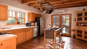 The sun-filled kitchen is fully equipped with pots, pans, utensils, & appliances