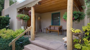 The front portal with seating, firewood and flowers welcome guests home