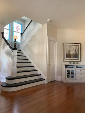 Main staircase with vintage newel post light and original stained glass windows