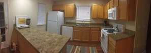 Full size appliances in fully equipped kitchen.