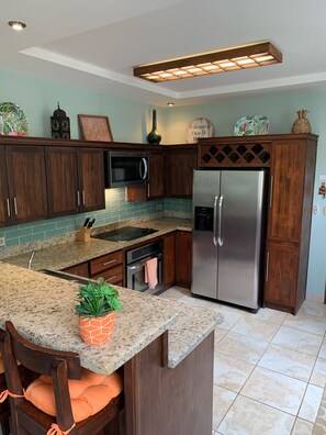 Fully stocked kitchen includes coffee maker, kettle, blender, and toaster. 